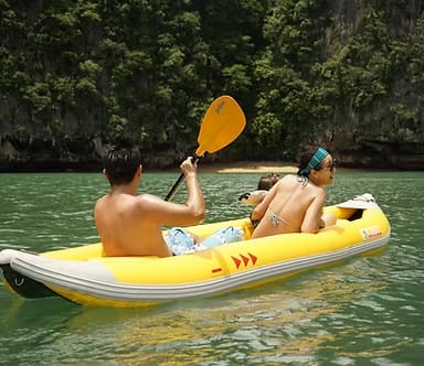 Couple kayaking through tropical coastal waters on a Java Yachting adventure in Krabi, Thailand