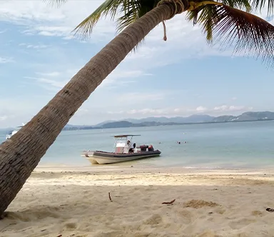 Motorboat anchored off a tropical beach during a Java Yachting boating experience in Thailand