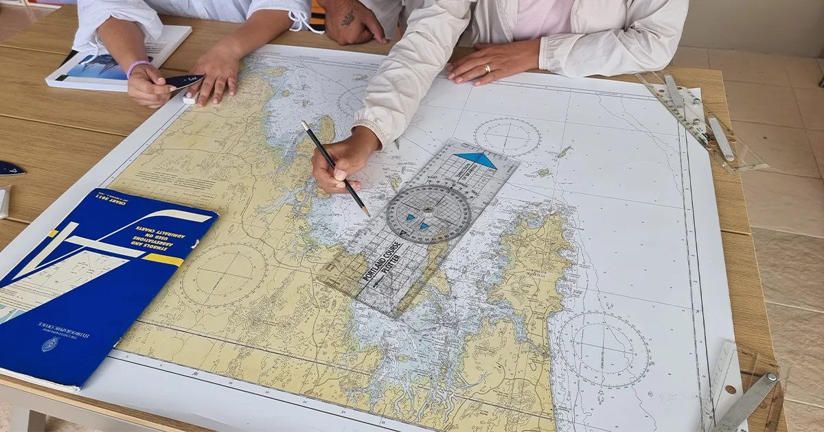 Students practising marine navigation and chartwork during Java Yachting sailing training in Thailand